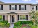 Charming townhome featuring a well-manicured lawn and black shutters that accentuate the gray facade at 1555 Dawnview Way, Kissimmee, FL 34744
