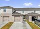 Townhome exteriors show garage access via driveways, and a courtyard style area behind the center unit at 1555 Dawnview Way, Kissimmee, FL 34744
