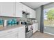 Well-equipped kitchen with stainless steel appliances, white cabinets, and a window overlooking the backyard at 1555 Dawnview Way, Kissimmee, FL 34744