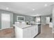 Open concept kitchen with island, stainless steel appliances, and view into the dining and living areas at 1555 Dawnview Way, Kissimmee, FL 34744