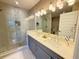 Well-lit bathroom featuring a double vanity and glass-enclosed shower at 16300 County Road 455 # 703, Montverde, FL 34756