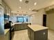 This open kitchen includes stainless steel appliances, light gray cabinetry, and an island at 16300 County Road 455 # 703, Montverde, FL 34756