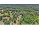 An aerial view of a single-story home nestled among mature trees in a heavily wooded area at 16758 Ne 135Th Ave, Fort Mc Coy, FL 32134