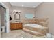 Comfortable bathroom featuring a vanity, commode, and garden tub with tiled surround at 16758 Ne 135Th Ave, Fort Mc Coy, FL 32134