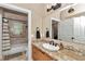 Bathroom with granite countertop vanity, tiled shower, and neutral color palette at 16758 Ne 135Th Ave, Fort Mc Coy, FL 32134