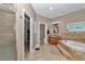Spacious bathroom showcasing a garden tub, tiled floors, and separate vanity area with ample storage at 16758 Ne 135Th Ave, Fort Mc Coy, FL 32134