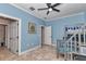Blue-walled bedroom featuring tile floors, a ceiling fan, and a gray bunk bed with stairs at 16758 Ne 135Th Ave, Fort Mc Coy, FL 32134