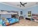 Spacious blue bedroom featuring a bunk bed, fan, and toys at 16758 Ne 135Th Ave, Fort Mc Coy, FL 32134