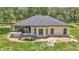 Rear exterior of home with screened-in porch and lush backyard at 16758 Ne 135Th Ave, Fort Mc Coy, FL 32134