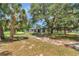 Home with mature landscaping, palm trees, and green lawn, showcasing the well-maintained exterior at 16758 Ne 135Th Ave, Fort Mc Coy, FL 32134