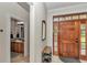 Elegant foyer with wood front door, bench, and entryway to the bathroom at 16758 Ne 135Th Ave, Fort Mc Coy, FL 32134