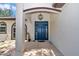 Covered front entryway with a blue door and decorative lighting, providing a welcoming entrance to the home at 16758 Ne 135Th Ave, Fort Mc Coy, FL 32134