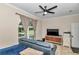 Cozy living room features a sofa, TV, ceiling fan, and views of the serene backyard at 16758 Ne 135Th Ave, Fort Mc Coy, FL 32134
