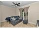 Comfortable living room featuring a sofa, ottoman, ceiling fan, and bright natural light at 16758 Ne 135Th Ave, Fort Mc Coy, FL 32134