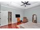 Tranquil main bedroom featuring hardwood floors, a ceiling fan, and an adjacent bathroom at 16758 Ne 135Th Ave, Fort Mc Coy, FL 32134