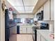 Bright kitchen features white cabinets, black appliances, and tile flooring at 1806 Foxhall Cir # 1806, Kissimmee, FL 34741