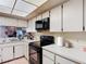 Well-lit kitchen with white countertops, black appliances, and tile flooring at 1806 Foxhall Cir # 1806, Kissimmee, FL 34741