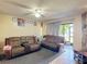 Inviting living room with tile floors, ceiling fan, and sliding glass doors to the outside at 1806 Foxhall Cir # 1806, Kissimmee, FL 34741