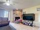 Cozy living room with a stone fireplace, ceiling fan, and sliding glass door for natural light at 1806 Foxhall Cir # 1806, Kissimmee, FL 34741