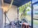 Covered patio area displaying exercise equipment and plant life with a view to the backyard at 1806 Foxhall Cir # 1806, Kissimmee, FL 34741