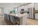 Modern white kitchen with stainless steel appliances, quartz countertops and island seating at 2080 Ashwood Bluff Dr, Ocoee, FL 34761
