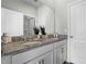 Dual sink bathroom featuring granite countertop, vanity, and an adjacent shower at 2092 Ashwood Bluff Dr, Ocoee, FL 34761