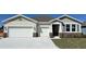 Charming single-story home featuring a three-car garage, stone accents, and well-manicured landscaping at 2117 Greenwood Oak Dr, Ocoee, FL 34761