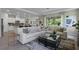 Bright, open-concept living room featuring a large sectional sofa and access to the kitchen and dining areas at 2117 Greenwood Oak Dr, Ocoee, FL 34761