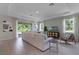 Expansive living room with wood-look tile floors, abundant natural light, and modern furnishings at 2117 Greenwood Oak Dr, Ocoee, FL 34761
