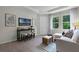 Bright living room features wood-look tile floors, large windows, and contemporary furnishings at 2117 Greenwood Oak Dr, Ocoee, FL 34761