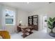 A well-lit home office features a unique desk, shelving, neutral carpet, and backyard views at 2117 Greenwood Oak Dr, Ocoee, FL 34761