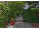 Lush greenery archway leads to brick patio area and concrete walkway with potted plants at 2238 Hawick Ln # 2238, Winter Park, FL 32792