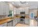 Modern kitchen with white cabinetry, granite countertops, stainless steel appliances, and tile flooring for a sleek cooking space at 2238 Hawick Ln # 2238, Winter Park, FL 32792