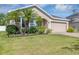 Inviting single-story home with well-manicured lawn and mature palm trees at 2426 Addison Creek Dr, Kissimmee, FL 34758