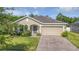 Charming single-story home with lush landscaping and a brick-paved driveway at 2426 Addison Creek Dr, Kissimmee, FL 34758