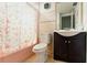 Compact bathroom featuring a toilet, sink, and shower with pink tub at 2504 Caribbean Ct, Orlando, FL 32805
