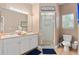 Bathroom featuring a double vanity, and a glass-enclosed shower with natural light streaming through the window at 2952 Lucayan Harbour Cir # 105, Kissimmee, FL 34746