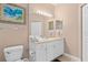 Comfortable bathroom with white vanity and a framed painting of umbrellas at 2952 Lucayan Harbour Cir # 105, Kissimmee, FL 34746