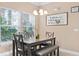 Cozy dining area with a chandelier and a decorative sign and lots of natural light from the window at 2952 Lucayan Harbour Cir # 105, Kissimmee, FL 34746