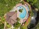 Aerial view of the community pool area with lots of seating and a jacuzzi, surrounded by lush greenery at 2952 Lucayan Harbour Cir # 105, Kissimmee, FL 34746