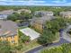 Aerial view of the property featuring well-kept grounds, a sand volleyball court, mature trees, and vibrant yellow buildings at 3561 Conroy Rd # 216, Orlando, FL 32839