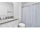 Bathroom featuring granite countertops, a toilet, and a stand-up shower with light gray curtains at 3624 Sungrove Cir, Sanford, FL 32771