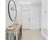Clean and modern entryway featuring tile floors, a decorative table with a round mirror and a white front door at 3624 Sungrove Cir, Sanford, FL 32771