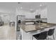 Stylish kitchen featuring stainless steel appliances, granite countertops, a breakfast bar, and sleek bar stools at 3624 Sungrove Cir, Sanford, FL 32771