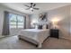 Comfortable bedroom features a ceiling fan, neutral walls, and a sunny window with stylish gray curtains at 3723 Alder Bark Ln, Sanford, FL 32773