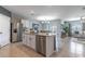 Open-concept kitchen with granite counters, stainless appliances, island, and view to dining and living areas at 3723 Alder Bark Ln, Sanford, FL 32773