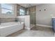 A bright bathroom with a soaking tub and glass enclosed shower featuring earth toned tile at 3865 W Stillwood Ln, Lake Mary, FL 32746