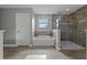 Bright bathroom featuring a soaking tub and glass-enclosed shower with tiled walls at 3865 W Stillwood Ln, Lake Mary, FL 32746