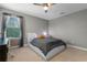 Neutral bedroom with ceiling fan, window, and dark curtains at 3865 W Stillwood Ln, Lake Mary, FL 32746