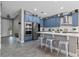 Modern kitchen boasts blue cabinets, stainless steel appliances, and a large island with seating at 3865 W Stillwood Ln, Lake Mary, FL 32746